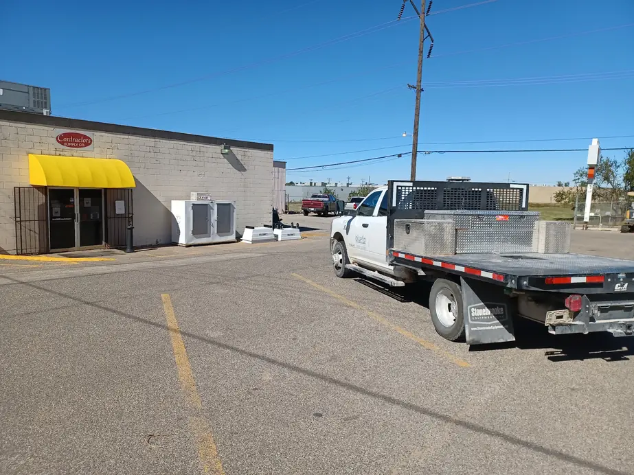 The Contractors Supply Co storefront on NE 30th Street, yellow awning over the customer entrance and the red oval sign on the block wall