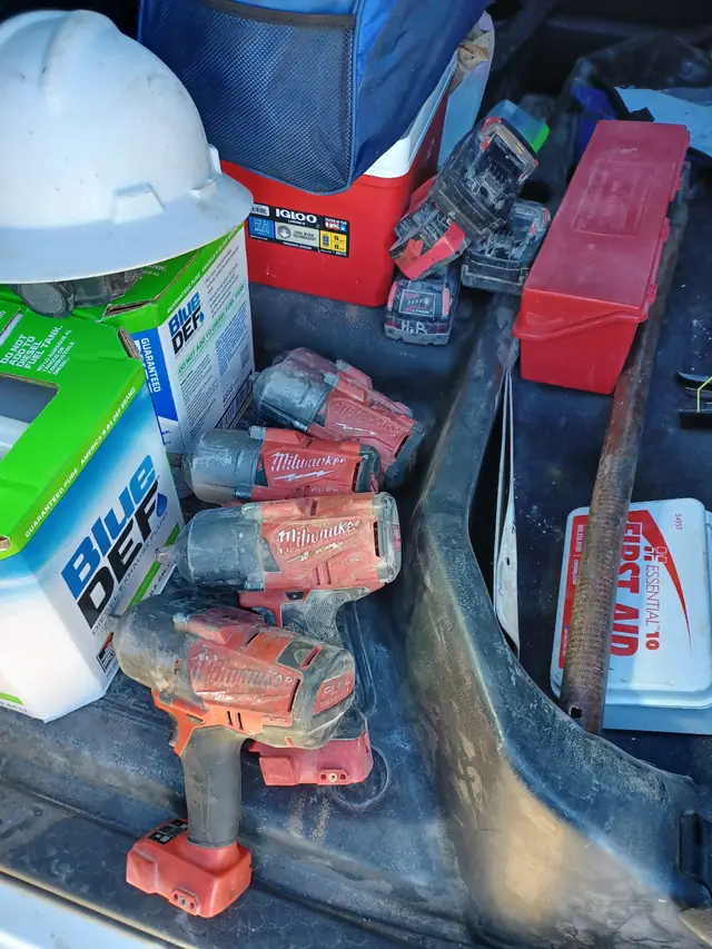 Milwaukee cordless power tools and a hard hat loaded in a customer truck bed